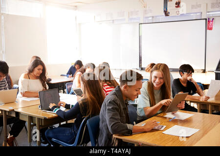 Ampio angolo di visione di alta scuola gli studenti seduti alla scrivania in Aula utilizzando computer portatili Foto Stock