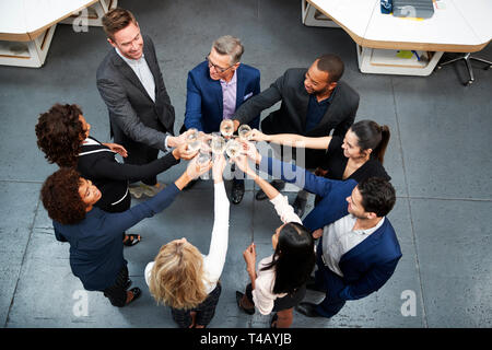 Colpo di overhead del Team Aziende per celebrare il successo con toast champagne in un ufficio moderno Foto Stock