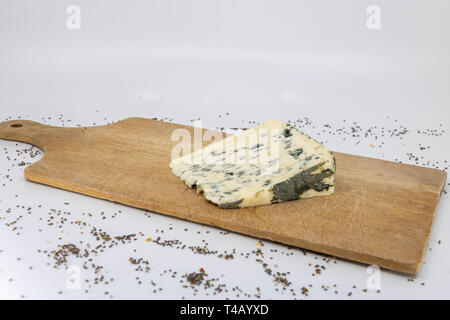 Fetta di formaggio blu con il latte di pecora su un tagliere di legno Foto Stock