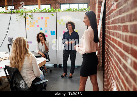 Femmina Team Creativo incontro per discutere le idee in un ufficio moderno Foto Stock