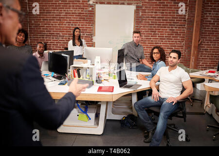 Imprenditore senior di parlare alla riunione di casualmente vestito Team Business di aprire ufficio del piano Foto Stock