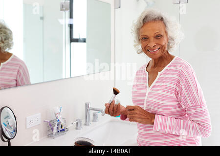 Ritratto di donna Senior in bagno mettendo su Make Up Foto Stock