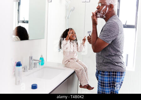 Nonno indossando pigiami in bagno mentre rasatura nipote orologi Foto Stock