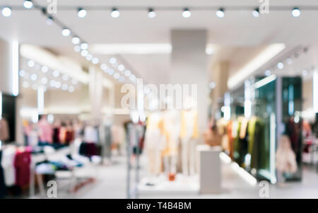 Abstract sfocato di moda negozio di abbigliamento boutique interno nel centro commerciale per lo shopping, con bokeh sfondo luminoso. Immagine sfocata di manichini all'interno di una donna f Foto Stock