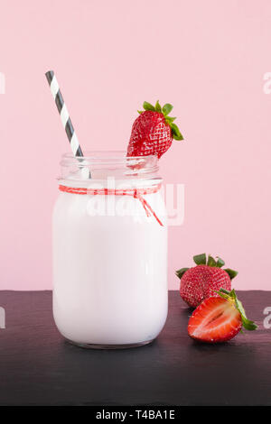 Frullato di fragole con berry a mason jar sul rosa. Close up. Bevanda estiva. Foto Stock
