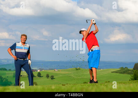 Padre e figlio giocando a golf nella luce della sera Foto Stock