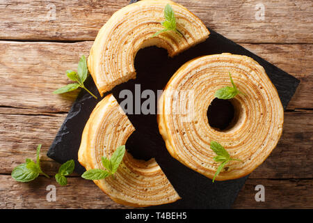 Il lituano sakotis o raguolis, polacco sekacz è un tradizionale torta allo spiedo close-up su di un tavolo di legno. Parte superiore orizzontale vista da sopra Foto Stock