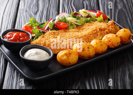 Il menu del ristorante di filetti di merluzzo in panatura con patate e verdura fresca insalata di close-up su una piastra sul tavolo orizzontale. Foto Stock