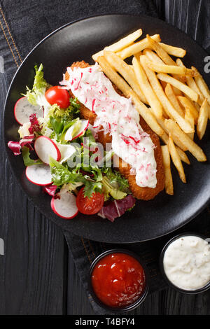 Pollock nel pangrattato guarnito con patatine fritte e insalata fresca closeup su una piastra. Verticale in alto vista da sopra Foto Stock