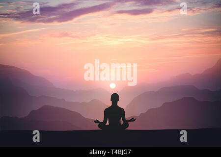 L'uomo le pratiche yoga e medita sulla montagna e al tramonto Foto Stock