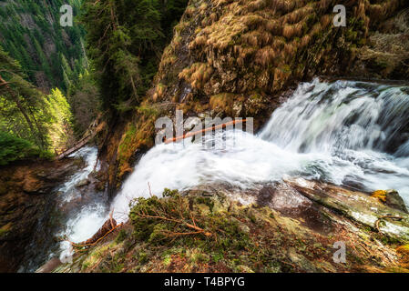 Cascata in montagna, guardando dall'alto. Ponte di legno in fondo. Uno splendido scenario dal Canyon di cascate in Bulgaria nei pressi di Smolyan città. Foto Stock