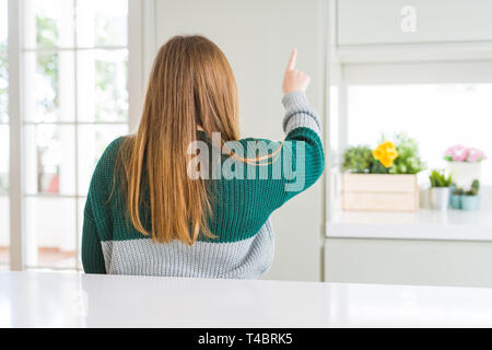 Giovani belle Taglie donna che indossa casual maglione a strisce in posa indietro rivolto in avanti con le dita la mano Foto Stock