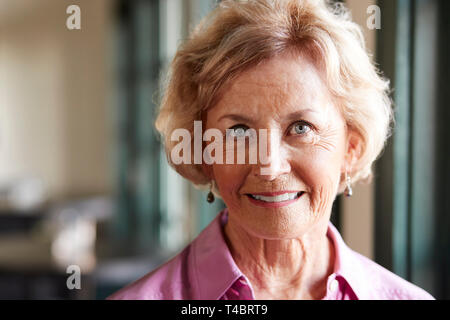 Ritratto di sorridere Senior donna seduta in Ristorante Foto Stock