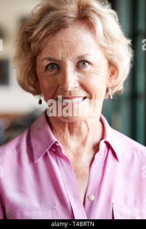 Ritratto di sorridere Senior donna seduta in Ristorante Foto Stock