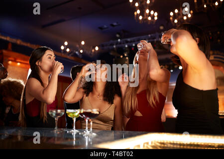 Il gruppo di amici di sesso femminile di bere colpi nel Cocktail Bar insieme Foto Stock