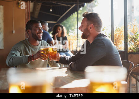 Due maschio riunione amici nel bar sport rendendo brindare insieme Foto Stock