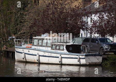 Vecchio incrociatore barca ormeggiata accanto al vecchio cottage sui Kennet & Avon, vicino al centro di Reading Foto Stock