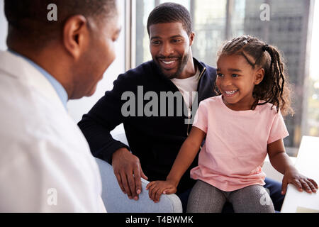 Padre e figlia avente la consultazione con la femmina pediatra in ospedale Office Foto Stock