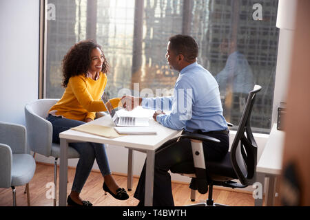 La donna si stringono la mano all'incontro con maschio Advisor finanziario Rapporto consigliere in ufficio Foto Stock