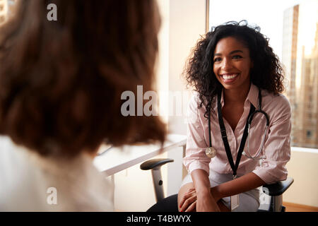 Al di sopra della spalla della donna con la consultazione con il medico donna in ospedale Office Foto Stock