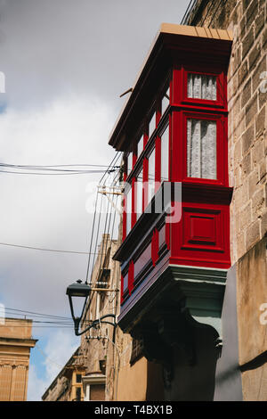 Tipico di legno tradizionale maltese rosso balcone a stretta strada medievale di Mdina, antica capitale di Malta, città medievale fortificata. Popolari Foto Stock