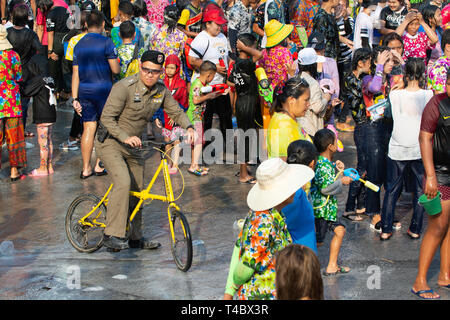 SUKHOTHAI, Tailandia - 15 Aprile 2019: popolo tailandese per celebrare il Nuovo Anno Songkran Festival dell'acqua sulla strada. Poliziotto su una bicicletta. Foto Stock