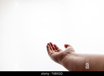 Una mano protesa con il palmo rivolto verso l'alto, contro uno sfondo bianco Foto Stock