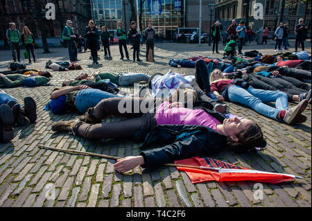 L'Aia, Paesi Bassi. 15 apr 2019. Un gruppo di attivisti sono visti giacente a terra fingendo di essere morto durante la protesta.la ribellione di estinzione (XR) è un movimento internazionale che utilizza non violenta di disobbedienza civile per conseguire un cambiamento radicale al fine di ridurre al minimo il rischio di estinzione umana e il collasso ecologico. Da lunedì 15 aprile, estinzione della ribellione sta prendendo provvedimenti per le strade delle città di tutto il mondo. Credito: ZUMA Press, Inc./Alamy Live News Foto Stock