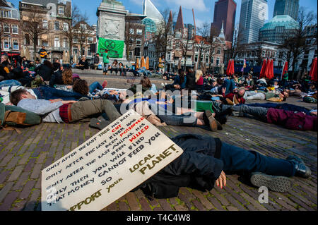 Un gruppo di attivisti sono visti giacente a terra fingendo di essere morto durante la protesta. La Ribellione di estinzione (XR) è un movimento internazionale che utilizza non violenta di disobbedienza civile per conseguire un cambiamento radicale al fine di ridurre al minimo il rischio di estinzione umana e il collasso ecologico. Da lunedì 15 aprile, estinzione della ribellione sta prendendo provvedimenti per le strade delle città di tutto il mondo. All'Aia, l' International ribellione XR Paesi Bassi' dichiarato la propria piena scala di ribellione alla domanda decisiva azione da parte dei governi sul cambiamento climatico e il collasso ecologico. Anche il sangue dei nostri C Foto Stock