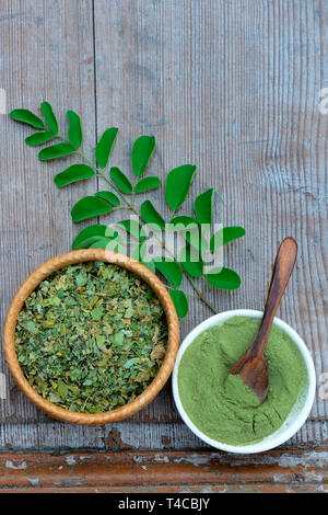 Moringa, Moringa-Pulver in Schale mit Holzloeffel, getrocknete und frische Moringablaetter, Moringapulver, Moringa Oleifera Foto Stock