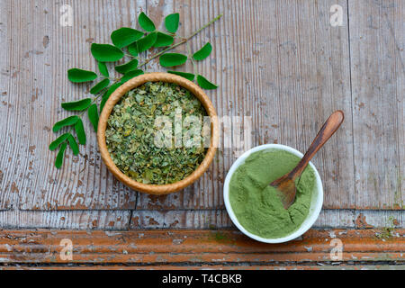 Moringa, Moringa-Pulver in Schale mit Holzloeffel, getrocknete und frische Moringablaetter, Moringapulver, Moringa Oleifera Foto Stock