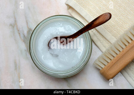 Kokosoel mit Holzloeffel, Handtuch mit Buerste Foto Stock