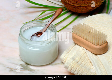 Kokosoel mit Holzloeffel, Handtuch mit Buerste Foto Stock