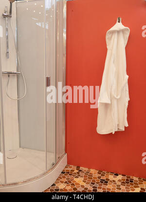 Cabina doccia al wellness centro spa con accappatoio bianco appeso alla  parete rossa Foto stock - Alamy