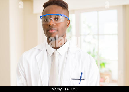 Africa scienziato giovane uomo che indossa gli occhiali di sicurezza lavorando con apparecchiature chimiche Foto Stock