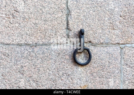 Anello di ghisa incorporato nella pietra di granito embankment per lo stazionamento delle barche. Foto Stock