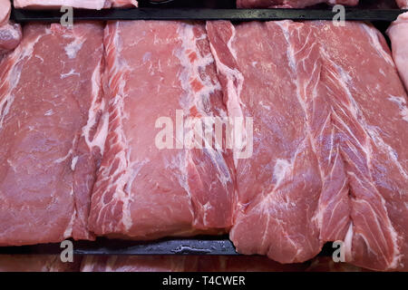 Pezzi di succosa carne cruda sul contatore al negozio di alimentari. Foto Stock