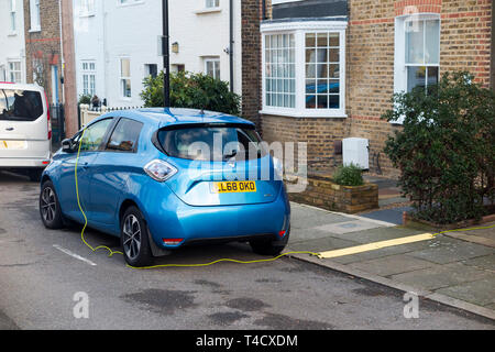 La Renault Zoe auto elettrica veicolo con batterie in carica utilizzando un cavo elettrico da un ambiente domestico. Regno Unito. (106) Foto Stock