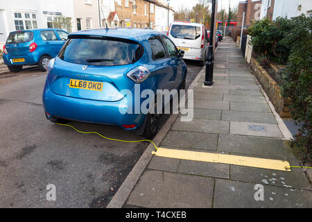 La Renault Zoe auto elettrica veicolo con batterie in carica utilizzando un cavo elettrico da un ambiente domestico. Regno Unito. (106) Foto Stock