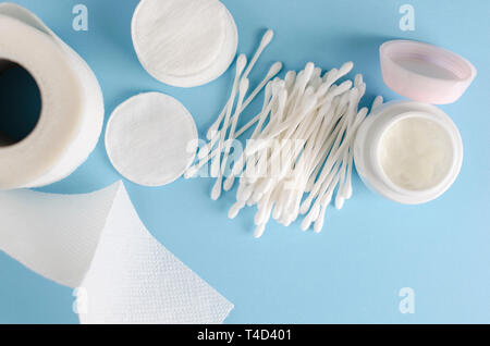 Orecchio bastoni, tamponi di cotone e carta igienica rotolo sul pastello blu sullo sfondo. Cura del corpo concetto. Vista superiore, piatto laici. Spazio di copia Foto Stock