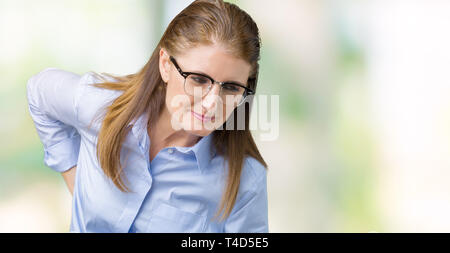 Bella la mezza età matura donna di affari con gli occhiali su sfondo isolati soffrono di mal di schiena, toccando torna con la mano, dolore muscolare Foto Stock
