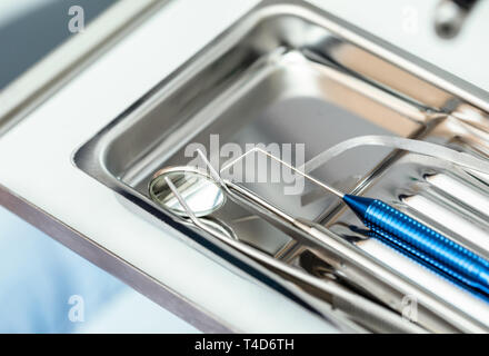 Close-up shot di sterilizzare gli strumenti dentali bocca specchio, sonda parodontale e forcipi sul vassoio di metallo pronto per essere utilizzato Foto Stock