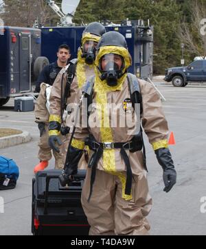 New York Esercito Nazionale personale Sgt. Kirstin Northrup (anteriore) e Sgt. Joshua Slish, reconnassiance i membri del team della seconda civile del Team di supporto, la testa fuori per controllare una stanza sospettato di contenere sostanze chimiche, biologiche, radiologiche o materiali, durante un esercizio a Hamilton College di Clinton, N.Y. il 21 marzo 2019. Membri del New York La Guardia Nazionale di seconda e XXIV civile il Team di supporto, il New Jersey e la Guardia Nazionale della ventunesima civile il Team di supporto, esercitazioni condotte dal 18 marzo al 21 a Hamilton College insieme con i membri del New York Polizia di Stato, Hamilton College di pubblica sicurezza, il nuovo Foto Stock