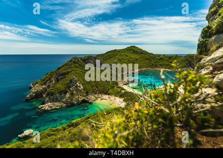 Afionas beach (Porto timoni) come visto da un angolo superiore con in primo piano in foglia, limpide acque azzurre e spiagge deserte a Corfù (Corfù, Grecia) Foto Stock