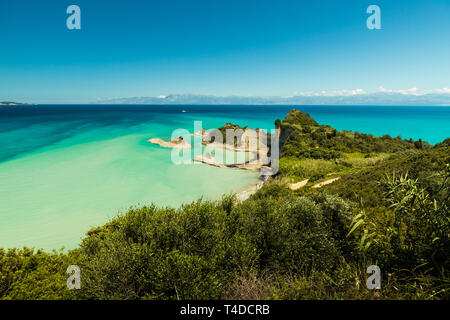 Cape Drastis (Perulades) con acque blu cristallo del mare su una soleggiata giornata estiva come visto da un punto più alto con l'Albania in background (Corfù) Foto Stock