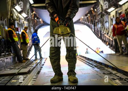 Un U.S. Air Force loadmaster aiuta a caricare un satellite su un C-17 Globemaster III Marzo 19, 2018 su Buckley Air Force Base, CO. La Lockheed Martin lungo con la Air National Guard e active duty componenti caricati i 70.000 pound cargo, è in grado di erogare la seconda unità GPS III Veicolo spaziale di Astrotech operazioni nello spazio in Titusville, in Florida per iniziare il lancio del satellite di elaborazione. Foto Stock