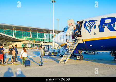 PORTO, Portogallo - 24 Maggio 2017: i passeggeri in partenza in aereo da scaletta, facciata di vetro di aeroporto in background Foto Stock