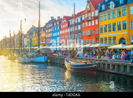 Vista di Nyhavn con barche da embankment al tramonto, persone, motion blur, Copenhagen, Danimarca Foto Stock