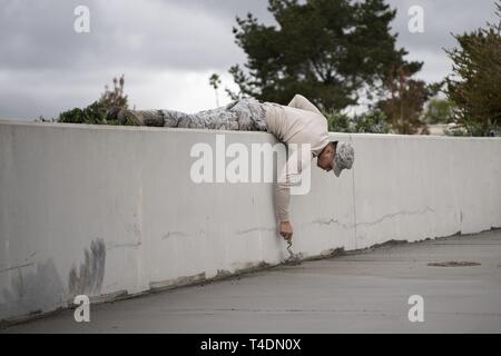 Senior Airman Noè Matsuura, 30 Ingegneria civile Squadron Airman, uniforma calcestruzzo bagnato Aprile 3, 2019, a Vandenberg Air Force Base in California Matsuura aiuta a mantenere Vandenberg AFB e fornire riparazioni e upgrade quando necessario. Foto Stock