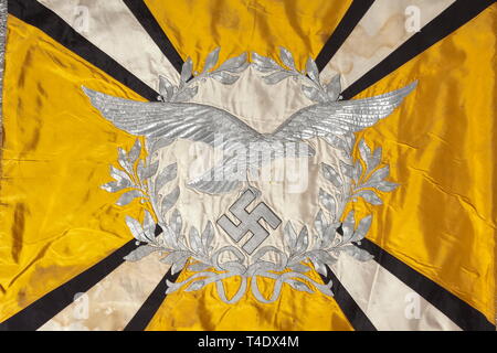Una bandiera del flying corps o paracadutisti di seta gialla con alluminio profuse ricami e frange di argento su tre lati (con perdite). Entrambe le facce recanti un disco bianco circondato da una corona di alloro sormontano diagonale quattro raggi Bianco si allarga verso i bordi, con nero framing, ciascuno di seta. Negli angoli svastiche orizzontale di seta nera con bordatura in argento. Nel centro del disco sulla destra un rilievo Luftwaffe eagle ricamati con varie filettature, sulla sinistra di fronte ad una croce di ferro. Sporco, con piccole riparazioni e perdite. Dimensioni ca. 140 x 125 cm. Terminale per tenda modello n., Editorial-Use-solo Foto Stock